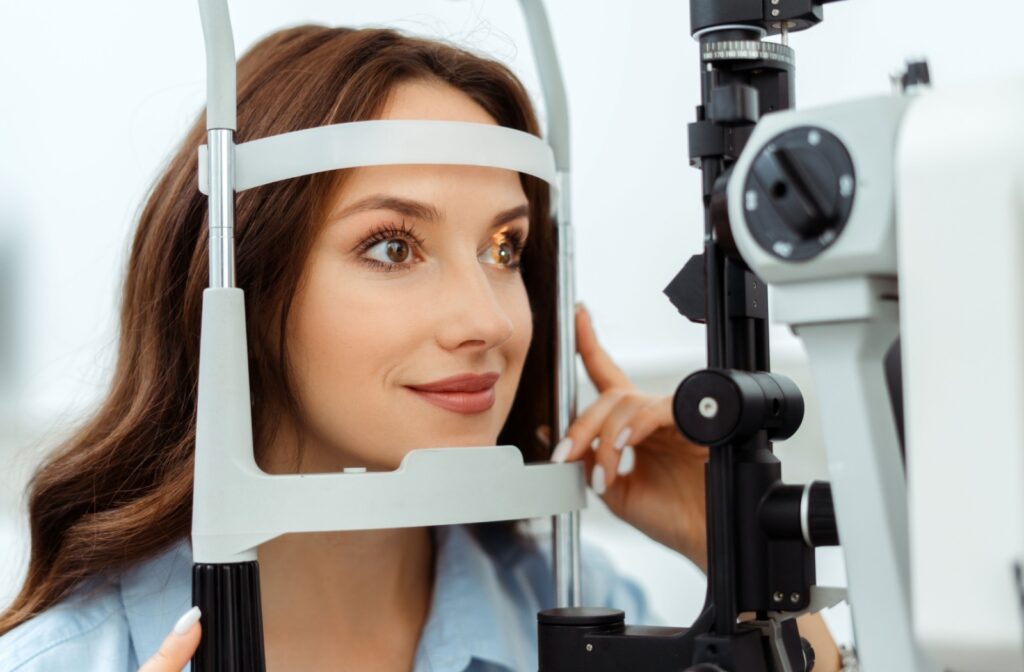 A young woman undergoing a slit lamp test as a part of her eye exam.