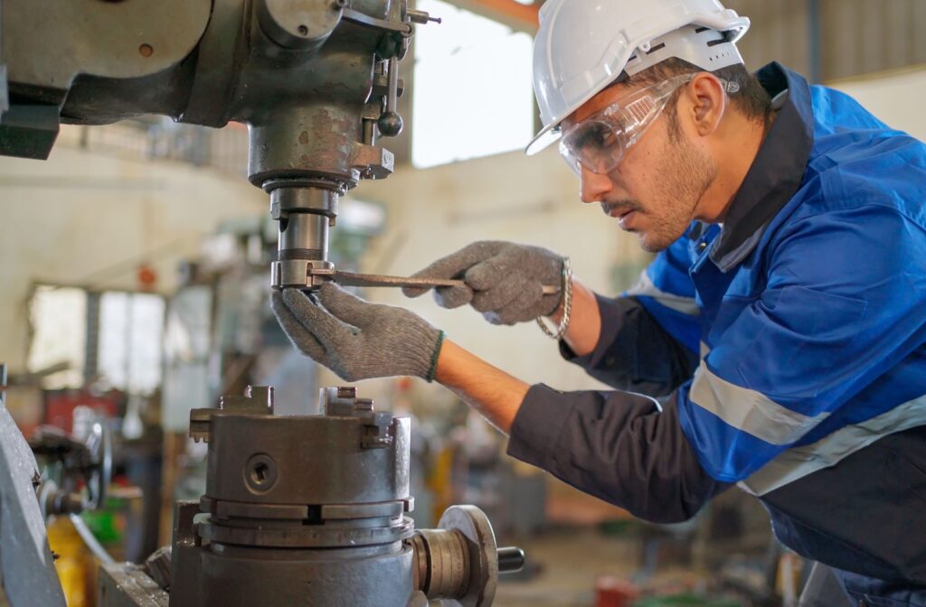 A mechanic focuses on his work while wearing a pair of safety glasses.