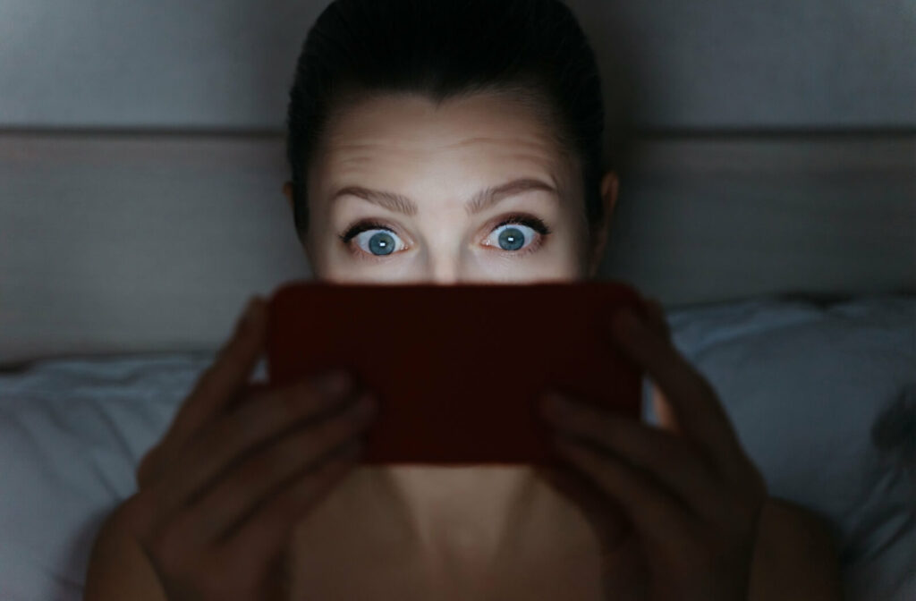 Woman straining her eyes looking at her phone